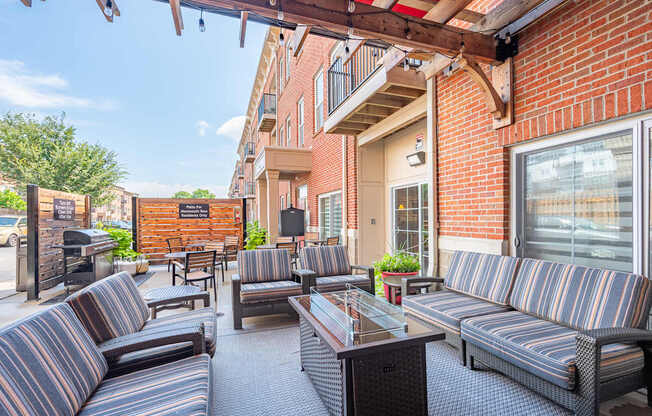 A patio with striped couches and a table with a glass top.