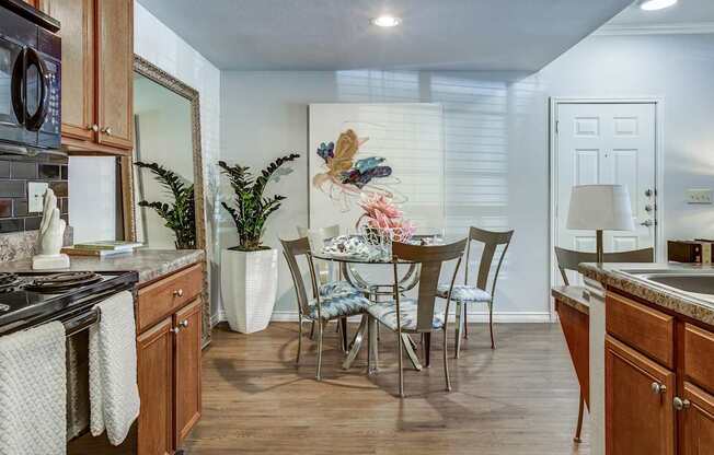 A kitchen with a dining table and chairs.
