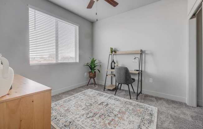 an office space with a desk and a chair and a window