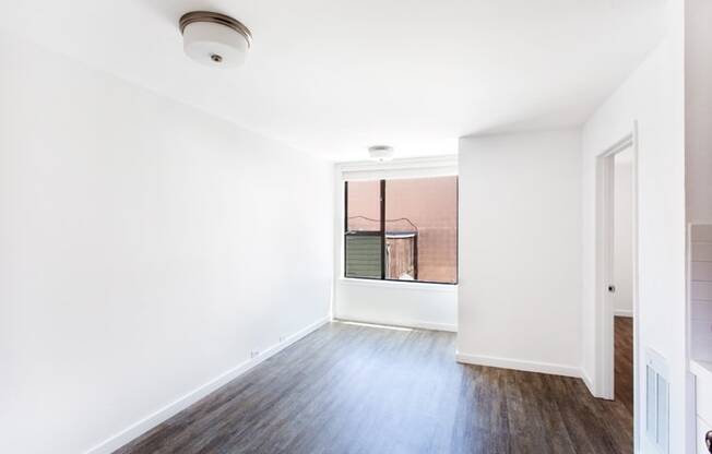 an empty room with white walls and a large window