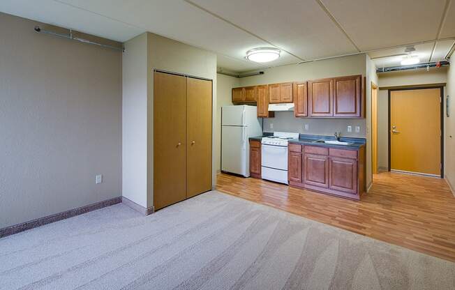 an empty living room and kitchen with wood flooring