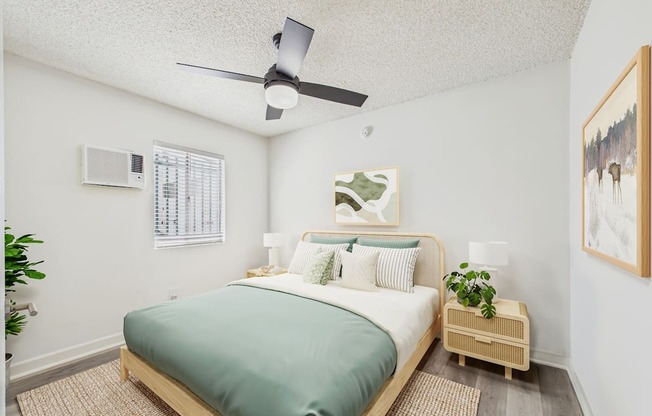 A bedroom with a bed, nightstand, and a ceiling fan.