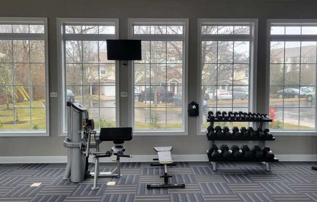 a gym with weights machines and a large window