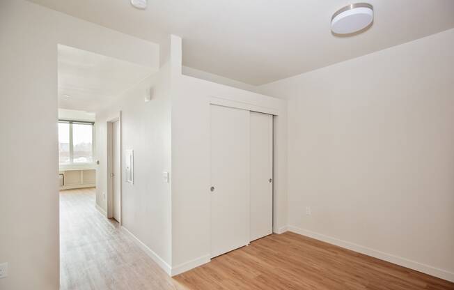 a living room with white walls and a wood floor