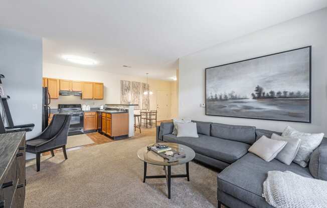 a living room with a couch and a coffee table in front of a kitchen