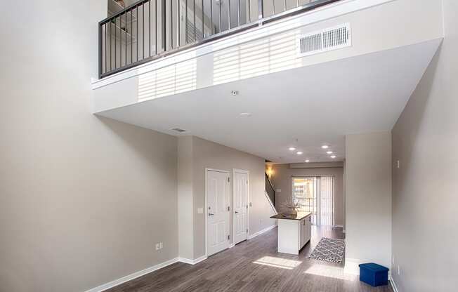 a spacious living room with a balcony and a kitchen