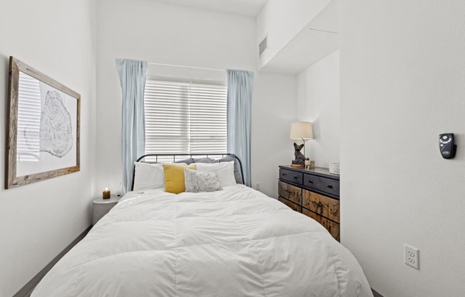 a bedroom with a white bed and a window