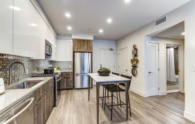 a kitchen with stainless steel appliances and a table with two stools