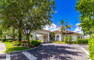 A white building with a large driveway in front.
