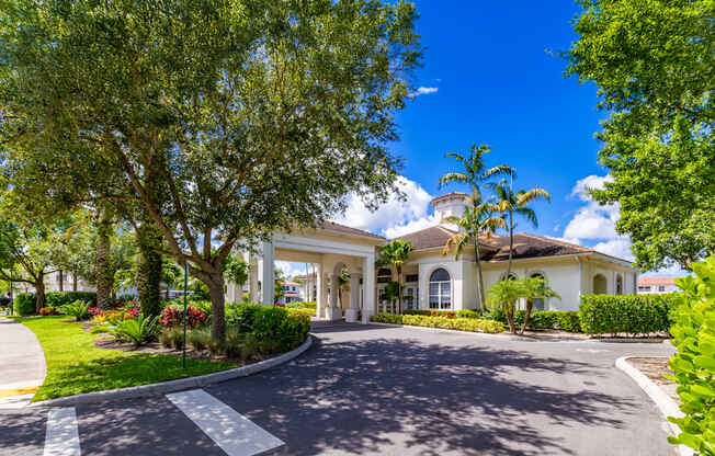 A white building with a large driveway in front.