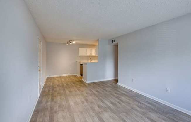 A room with wooden flooring and white walls.