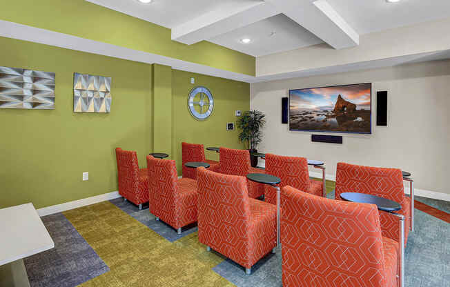 a waiting room with orange chairs and green walls