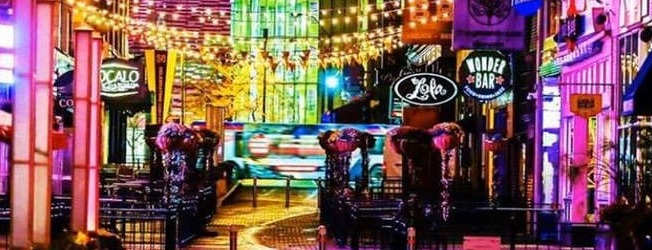 a city street filled with lots of neon signs at East 4th Street, Ohio, 44115