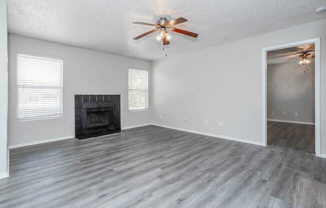 A room with a fireplace and a ceiling fan.