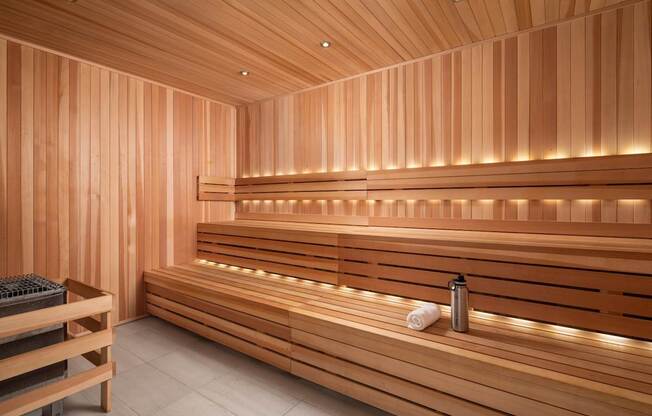 A wooden sauna with benches and lights.