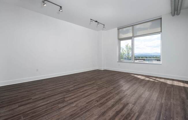 A room with a window overlooking a landscape.