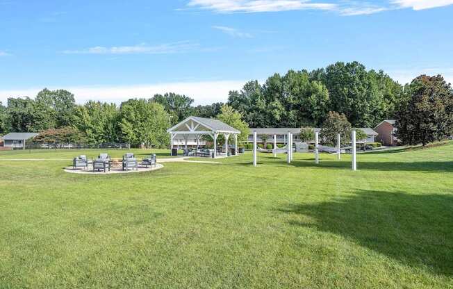 a park with picnic tables and a pavilion on the grass
