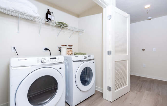 Two white front loading washing machines in a laundry room.