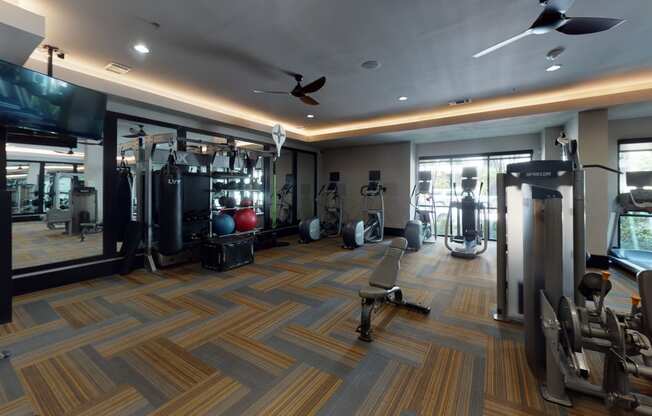 a spacious fitness room with cardio equipment and a flat screen tv