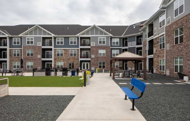 a walkway with benches and a gazebo at the whispering winds apartments in pear