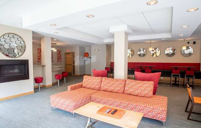 A living room with a red couch and a fireplace.