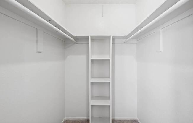 A walk-in closet with built-in shelves and hanging space
