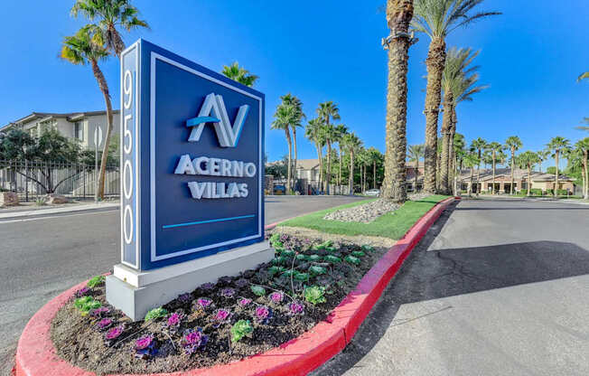 A blue sign with the letters "AV" and "Acerno Villas" on it is in front of some palm trees.