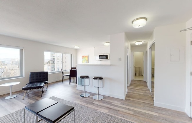 a living room with white walls and hardwood floors