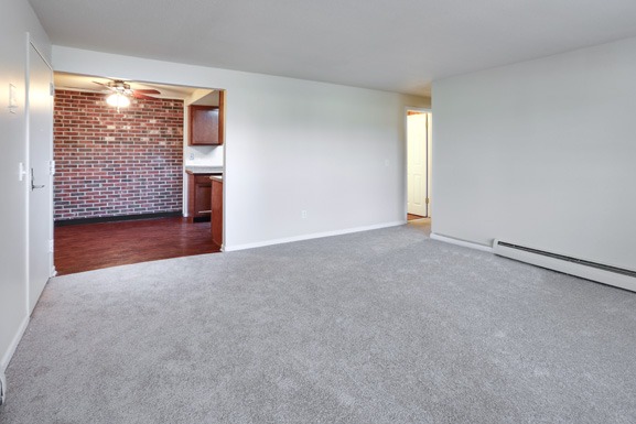 an empty living room with a brick wall