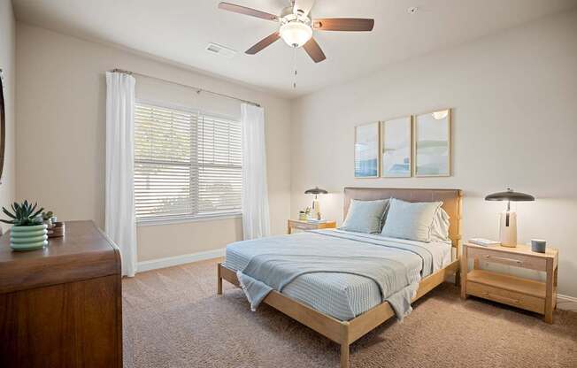 A bedroom with a bed, nightstand, and a ceiling fan.