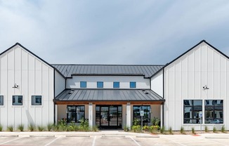 A modern building with a black roof and white walls.