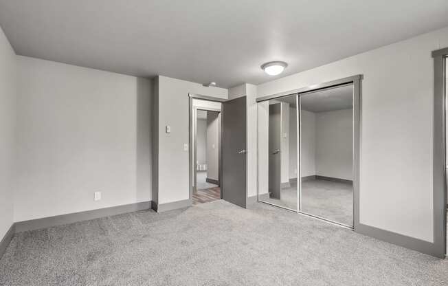 A spacious room with a carpeted floor and a sliding glass door.