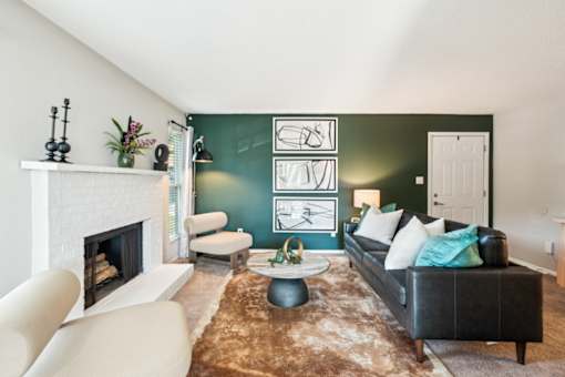 A living room with a fireplace, a couch, and a rug.