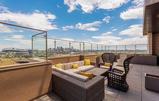 a balcony with a view of a city and a patio with furniture