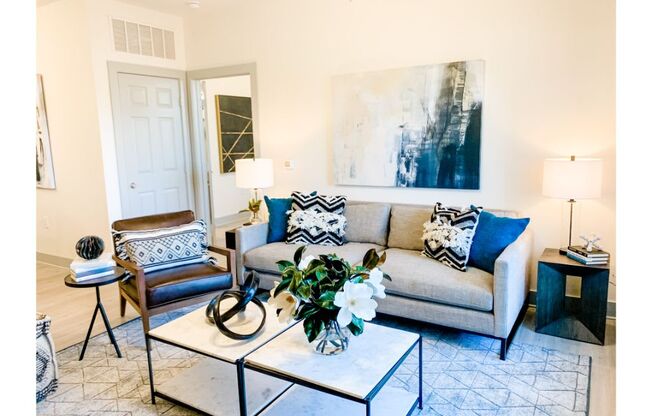 a living room with a gray couch and blue and white pillows