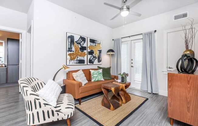 A living room with a striped chair, a wooden coffee table, and a painting on the wall.