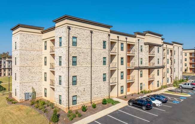 a large apartment building with cars parked in a parking lot