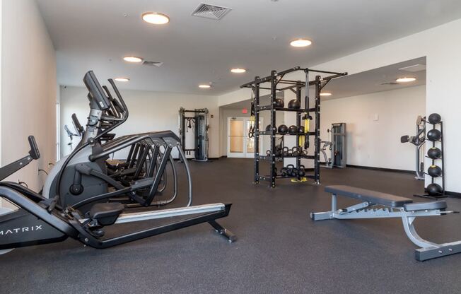 a large fitness room with exercise equipment and weights
