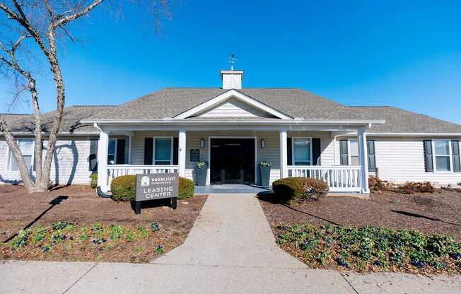A house with a sign that says "Leasing Center" in front of it.