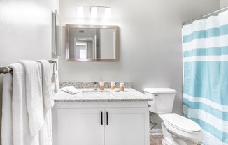 a white bathroom with a blue and white shower curtain