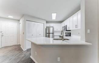 A kitchen with white cabinets and a white countertop.