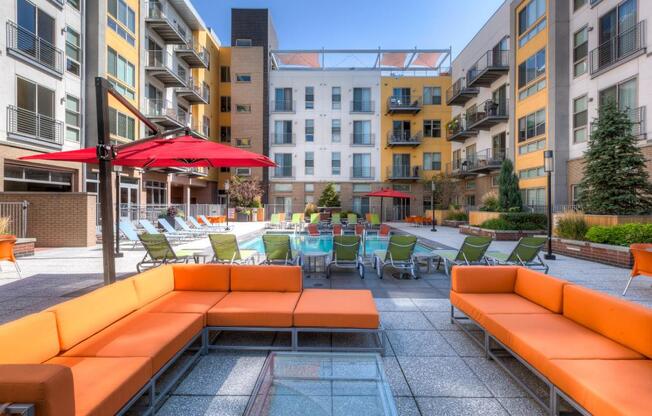 an outdoor lounge area with tables and chairs in an apartment building