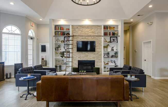 a living room with couches and chairs and a fireplace with a tv on the wall