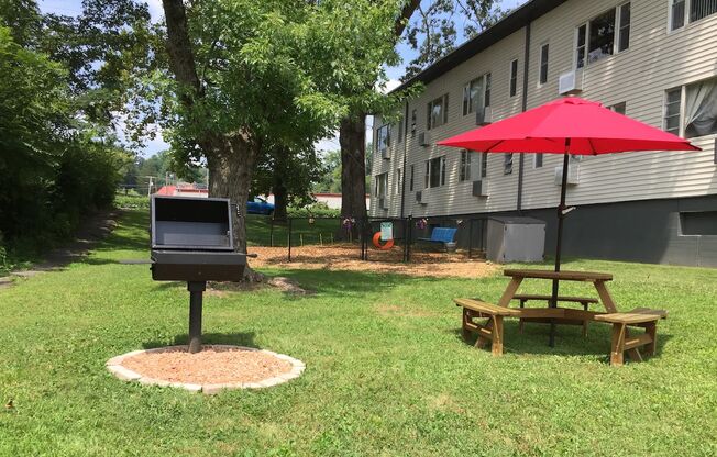 grilling and shaded picnic table by the dog park at The Flats at Jackson Square