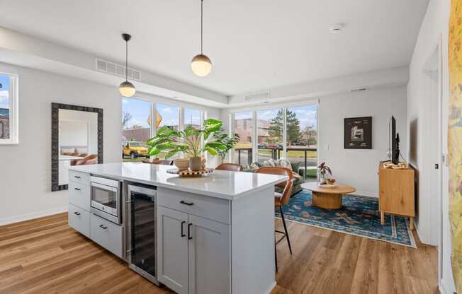 an open kitchen with a large island and a living room with a table and chairs