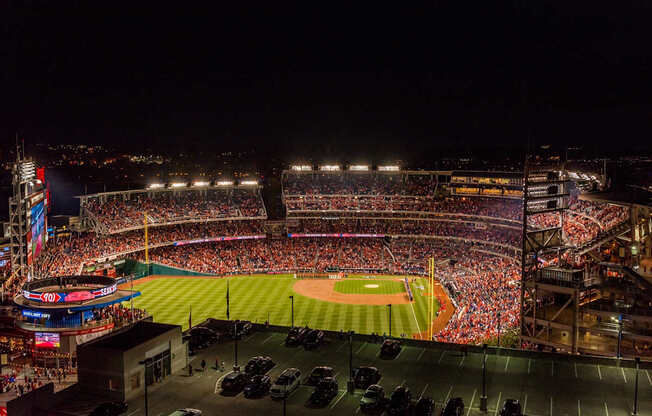 A packed baseball stadium is shown at night.