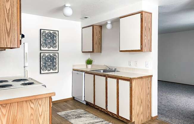 our apartments offer a kitchen with white appliances and wood cabinets at Shiloh Glen, Billings, MT 59102