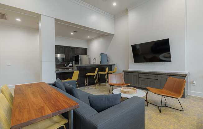 a living room with a couch table and chairs and a kitchen