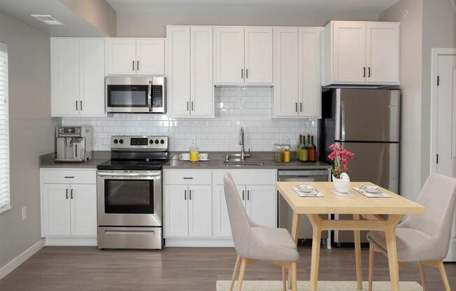 studio kitchen with white cabinets and stainless steel appliances