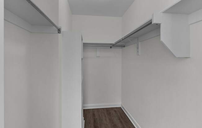 an empty room with white walls and a wood floor